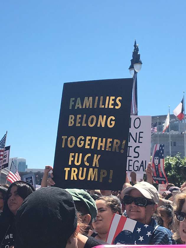 La bannière de protestation contre la politique d'immigration de Trump se lit comme suit: `` Les familles vont ensemble! Putain Trump! '