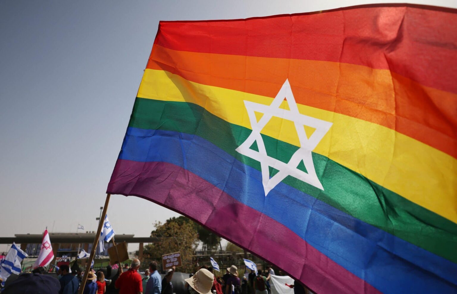 Le drapeau LGBT flotte en signe de protestation alors que les homophobes entrent à la Knesset