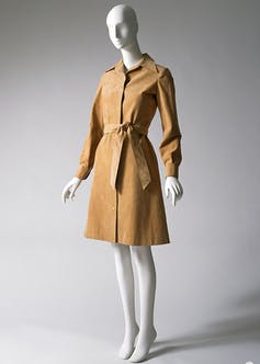 Un mannequin vêtu d'une robe chemise Halston beige.