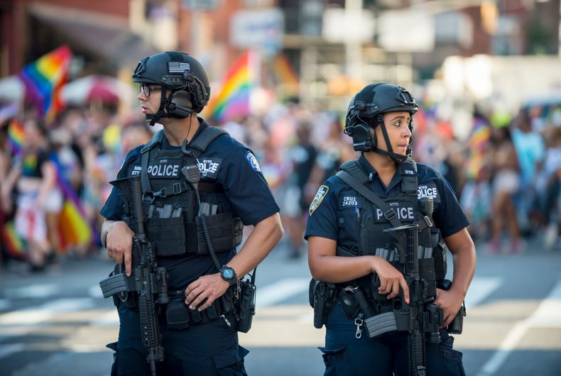 25 juin 2017: les agents de police du NYPD se tiennent avec les mains sur leurs armes, assurant la sécurité en marge de la parade annuelle de la Gay Pride alors qu'elle traverse Greenwich Village.