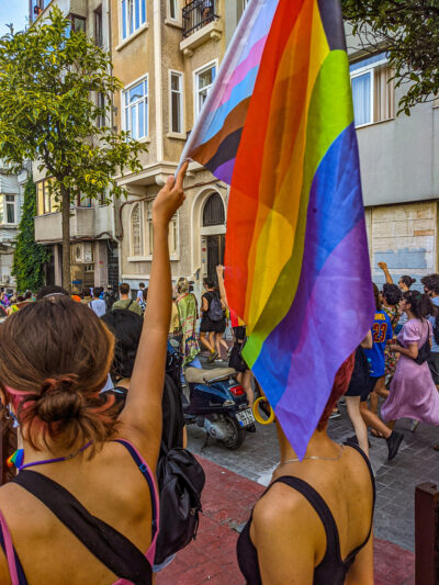 Deux femmes, dont une brandissant un drapeau Progress Pride, lors d'une marche non autorisée reconnaissant la fierté à Istanbul, en Turquie, le 17 juin 2021.