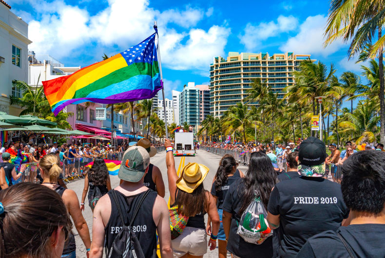 MIAMI, FLORIDE / ÉTATS-UNIS - 9 AVRIL 2019 : Pride Parade sur Ocean Drive à Miami Beach.  Un drapeau américain LGBTQ Pride est agité.