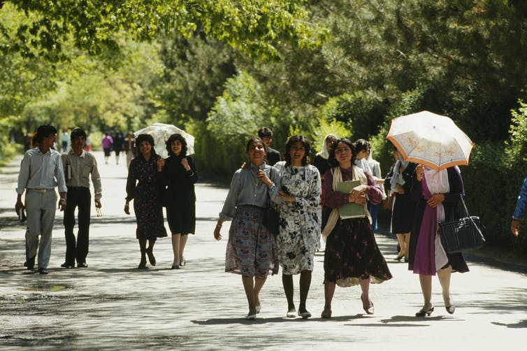 Des jeunes hommes et femmes se promènent dans le parc de Kaboul.