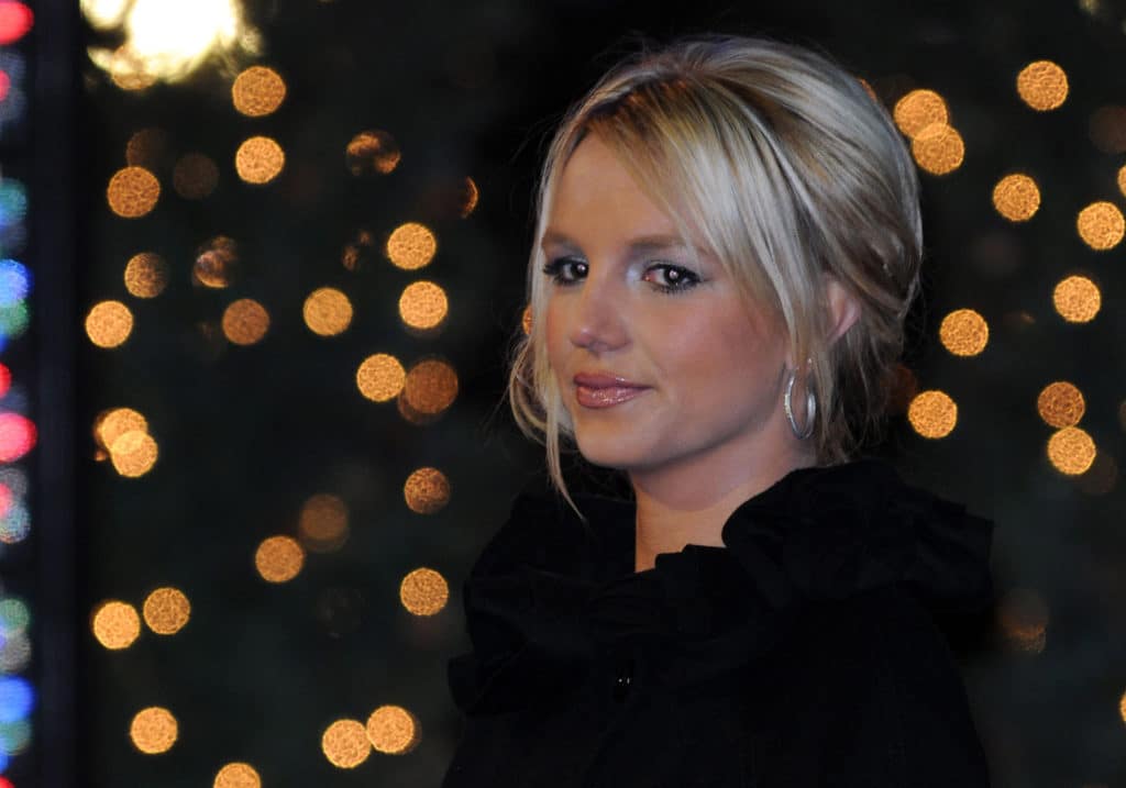 Britney Spears sourit légèrement sur fond de lumières floues