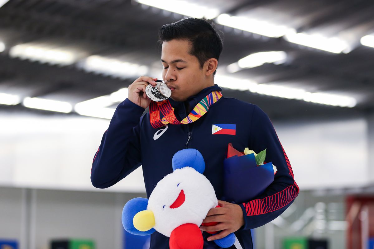 Christopher Caluza embrassant une médaille.