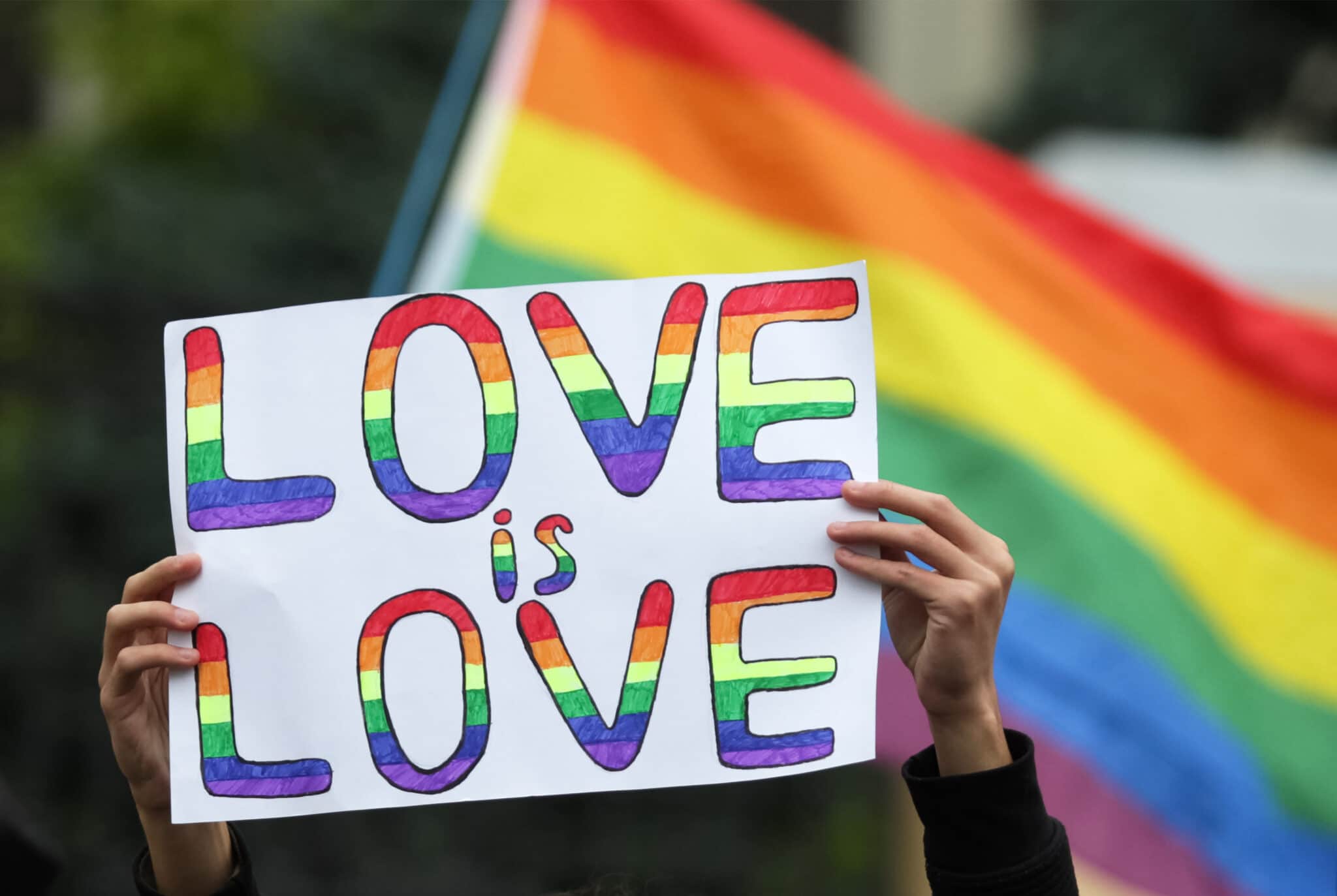 Un participant tient une pancarte qui dit que l'amour est l'amour lors de la Marche pour l'égalité KyivPride 2021 de la communauté LGBT.