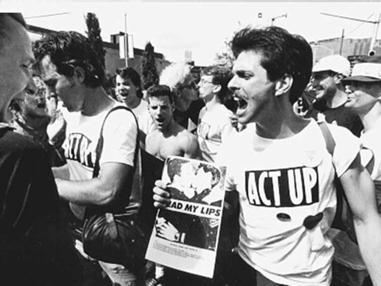 Des hommes portant des t-shirts ACT UP lors d'une manifestation.