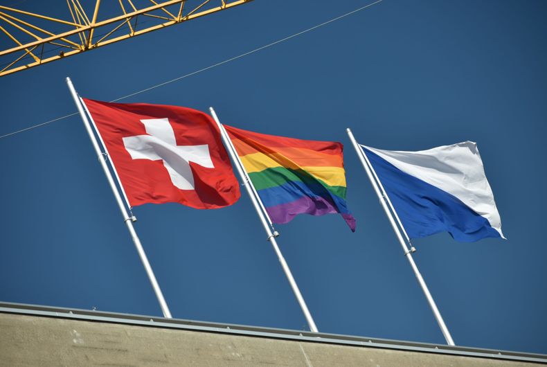 Le drapeau de la Suisse (à gauche) et de la plus grande ville du pays, Zurich (à droite) agitant le drapeau de la fierté (au centre).