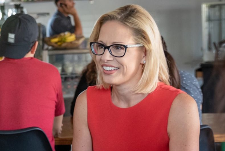 Kyrsten Sinema en blouse rouge dans un restaurant.