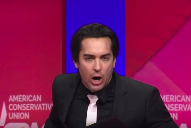 Brandon Straka est un homme blanc débraillé vêtu d'un costume noir et d'une cravate blanche s'exprimant lors de la Conférence d'action politique conservatrice