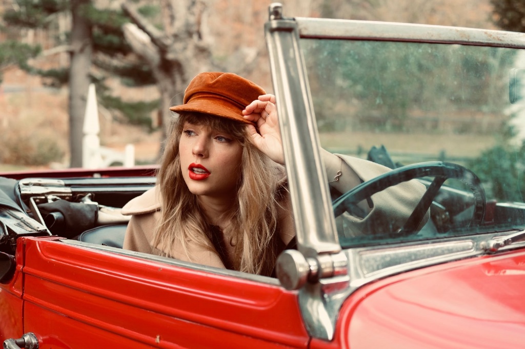 Taylor Swift assise dans une voiture dans une image promotionnelle pour Red (Taylor's Version)