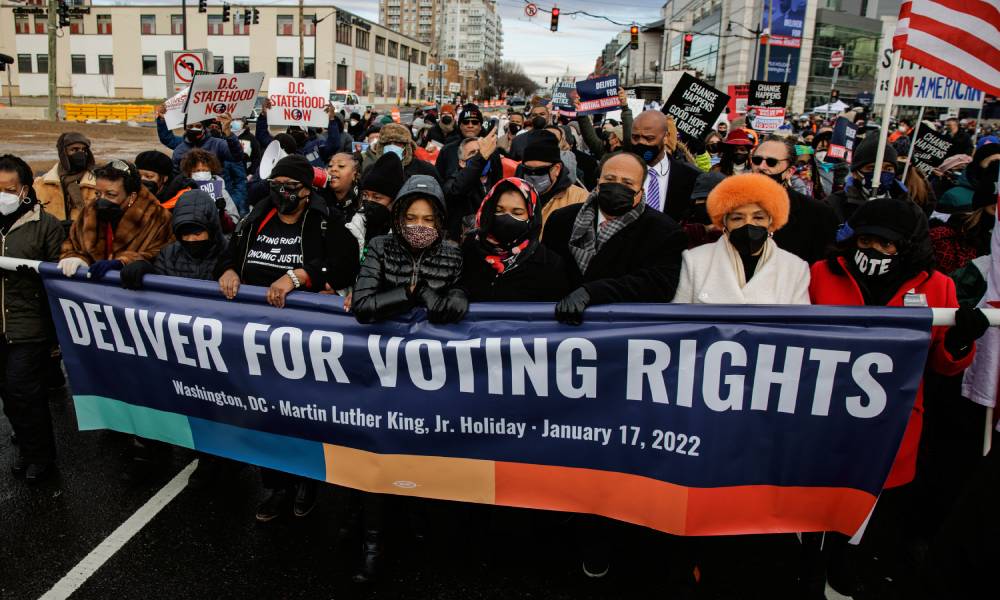 Membre de la famille de Martin Luther King Jr et défenseurs des droits civils mars avec une bannière qui se lit "livrer pour le droit de vote"