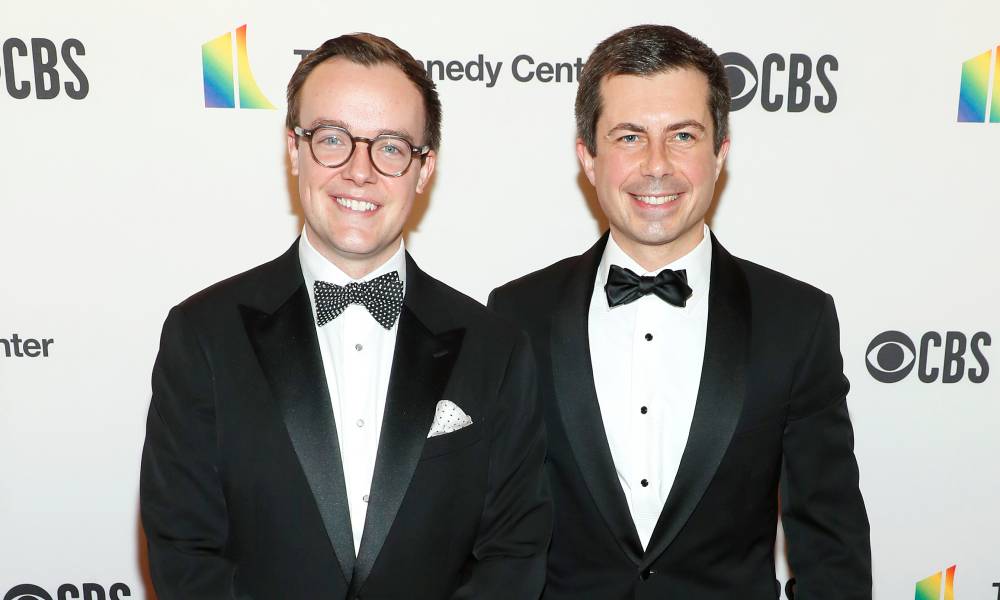Pete et Chasten Buttigieg, qui sont maris, sont habillés en costumes et cravates pour un événement