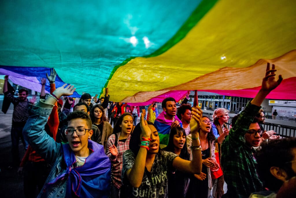 Les gens brandissent un drapeau LGBT + Pride lors d'une marche