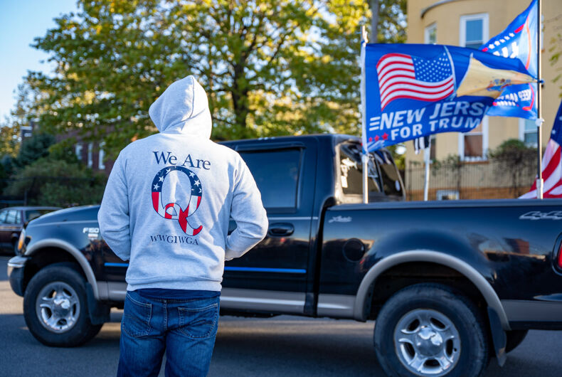 Weehawken, New Jersey, États-Unis - 2 novembre 2020 - jour avant le jour des élections Trump Rally - homme à capuche portant un sweat-shirt Qanon au Trump Rally avec camion et drapeaux devant lui .