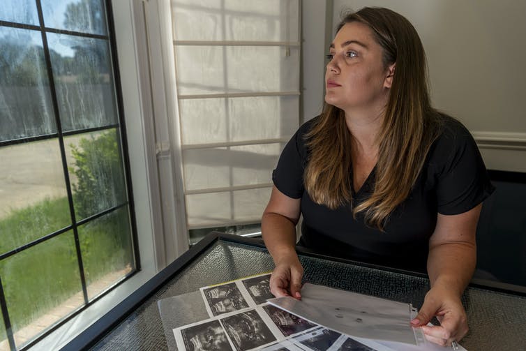 Une femme est assise avec des images d'échographies