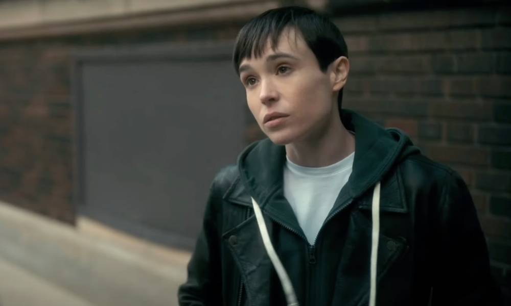 Le patron de l’Umbrella Academy a réécrit toute la saison après la sortie d’Elliot Page : « C’est tout à l’honneur d’Elliot » Elliot Page appears as his character from the Netflix show The Umbrella Academy. The character, Viktor, is wearing a white t-shirt and blue hooded sweatshirt as he stands outside and talks to someone off screen