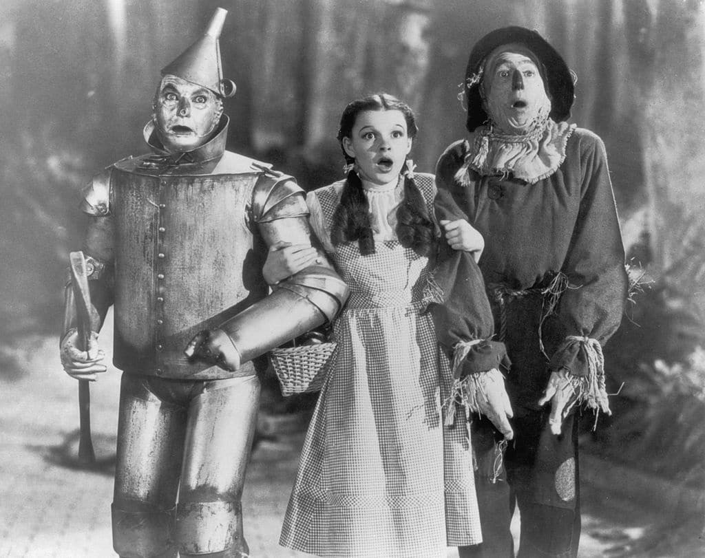 Le Tin Man (Jack Haley), Dorothy (Judy Garland) et l'Épouvantail (Ray Bolger) se lancent dans leur quête d'accomplissement dans Le Magicien d'Oz. 