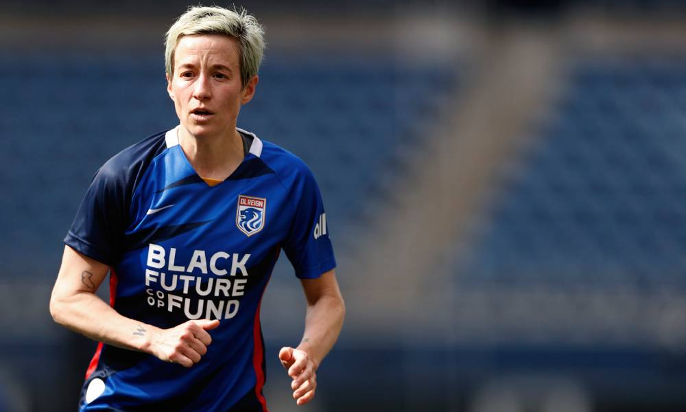 Megan Rapinoe porte un maillot bleu OL Reign avec les mots "Black Future Coop Fund" écrits en blanc sur son torse alors qu