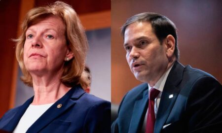 In the image on the left, Tammy Baldwin wears a white shirt and blue blazer with a small golden pin as she stands at a podium. In the image on the right, Marco Rubio wears a white button-up shirt, red tie and blue suit jacket as he speaks to someone off camera