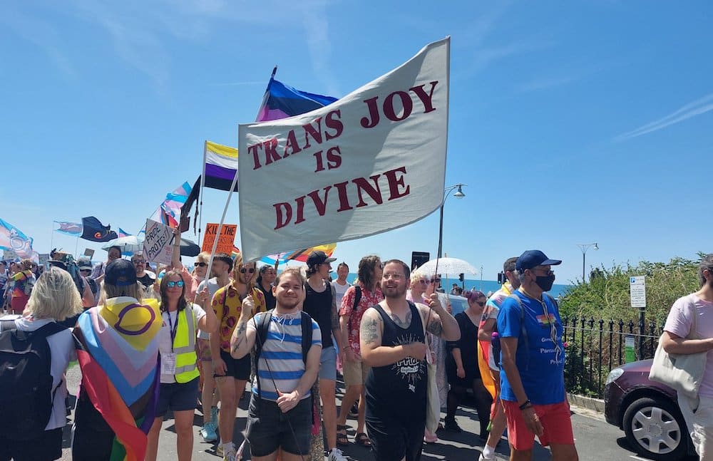 20 000 personnes défilent pour les droits et la libération des trans à Trans Pride Brighton A protester holds a flag that reads 'trans joy is divine' at Trans Pride Brighton