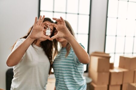This stock photo shows a lesbian couple hold keys to a new home.