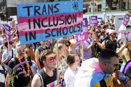 pro-LGBTQ+ protestors marching for trans inclusion in schools.