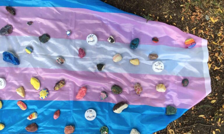 A memorial placed on a trans Pride flag after a young trans man was attacked in Münster, Germany