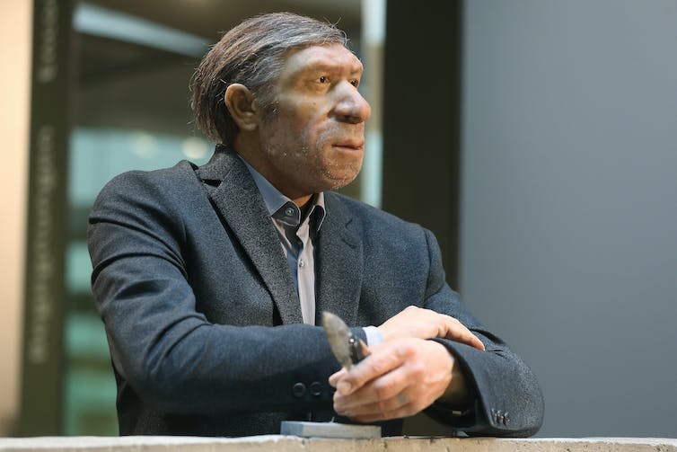 Recréation par l'artiste d'un homme de Néandertal vêtu d'un costume d'affaires moderne