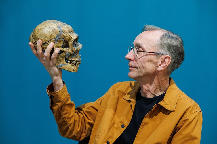 photo d'un homme tenant un crâne humain et regardant le visage