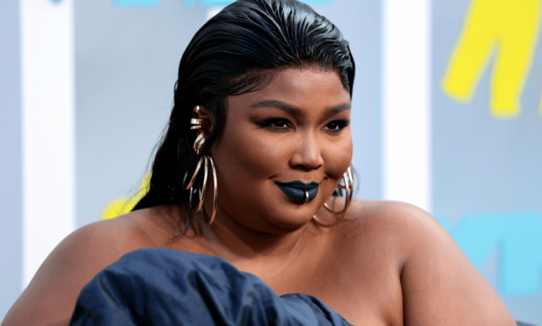 Lizzo wears a blue outfit as she poses for a photo at an event