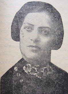 Un portrait en noir et blanc de la tête d'une femme aux cheveux noirs jusqu'aux oreilles, avec une expression sérieuse.