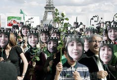 Les gens portent des pancartes du visage d'une femme aux cheveux noirs.