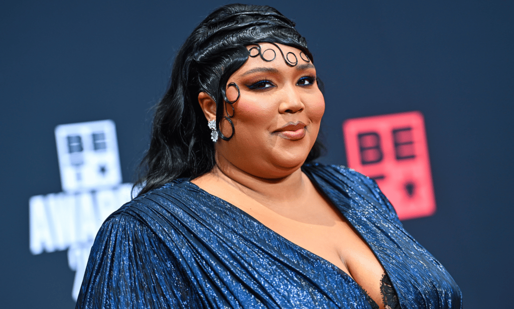 Lizzo porte une tenue bleue alors qu'elle pose pour une photo lors d'un événement