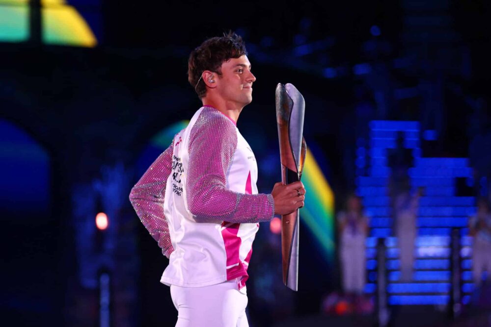 Tom Daley porte le Queen's Baton lors de la cérémonie d'ouverture des Jeux du Commonwealth.