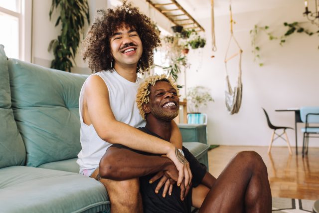 Couple queer s'embrassant à l'intérieur