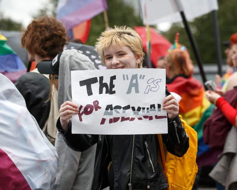 Une personne est titulaire d'un signe indiquant 'Le 'A' est pour asexué.'