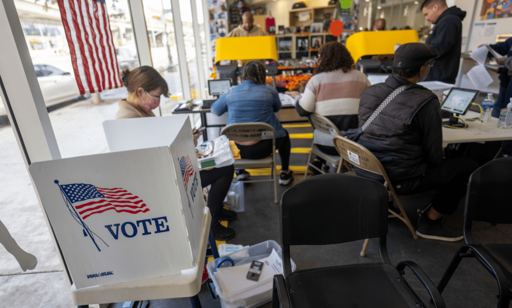 Plusieurs personnes se rassemblent dans un bâtiment pour voter lors des élections américaines de mi-mandat