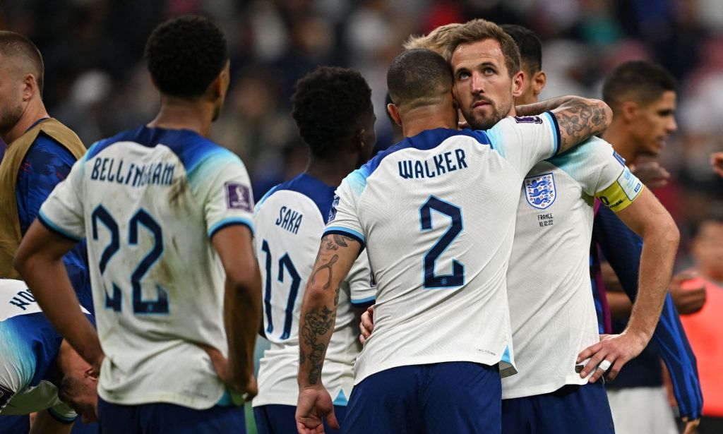 Harry Kane est embrassé par un joueur de football alors qu'il est entouré de joueurs encore bizarres dans leurs kits blancs d'Angleterre.