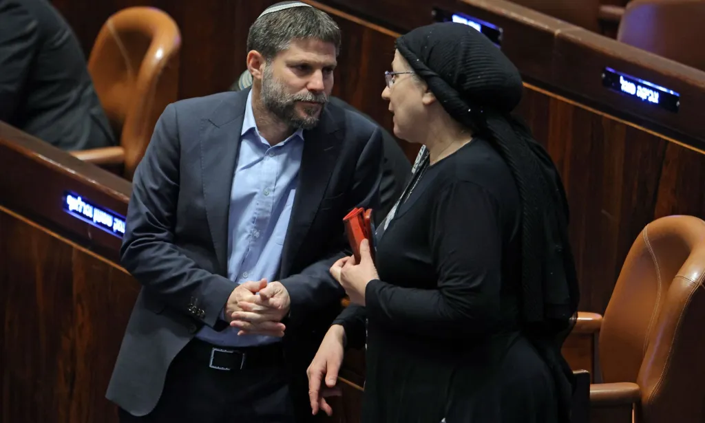 Membre de la Knesset israélienne Bezalel Smotrich (L), chef du parti sioniste religieux, parle avec son collègue et membre du parti Orit Strook (R) lors d'une session élue