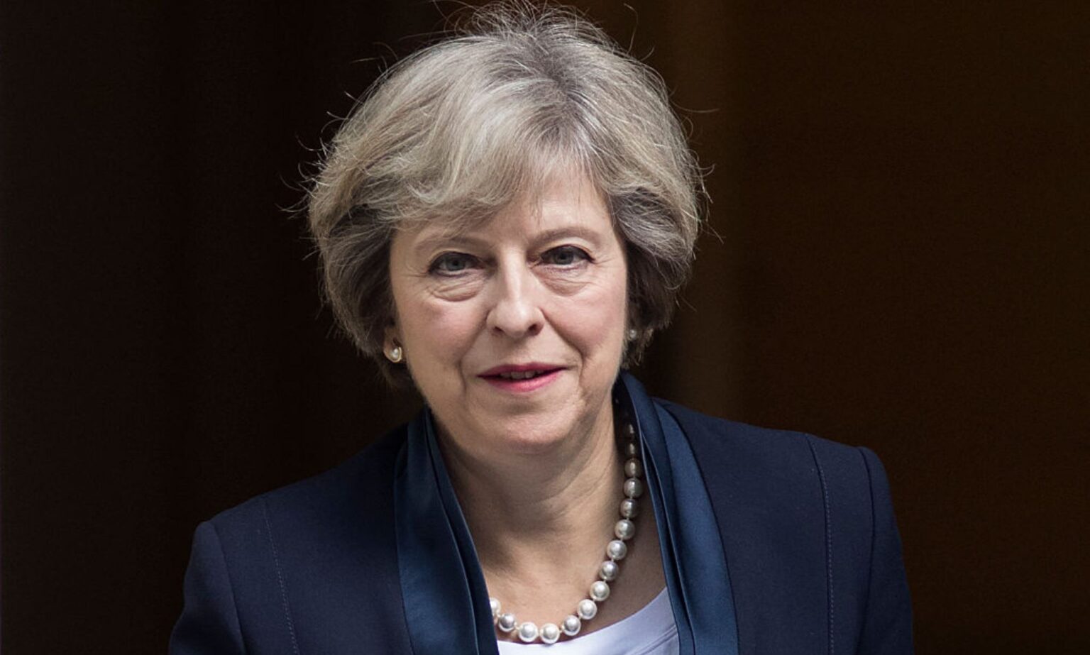 Theresa May déçue que Westminster n’envisage pas une réforme de la loi sur le genre comme l’Écosse A photo shows former prime minister Theresa May wearing a navy suit leaving Westminster.