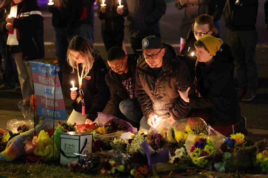 Un groupe de personnes, certaines avec des bougies, organisent une veillée à un mémorial de fortune près de la discothèque Club Q le 20 novembre 2022 à Colorado Springs après une fusillade de masse meurtrière