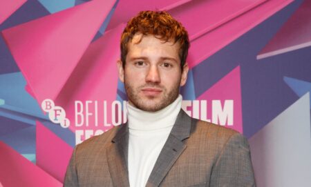 Actor Alexander Lincoln wearing a silver grey suit jacket over a white turtleneck sweater poses for the cameras at the London Film Festival. (Getty)
