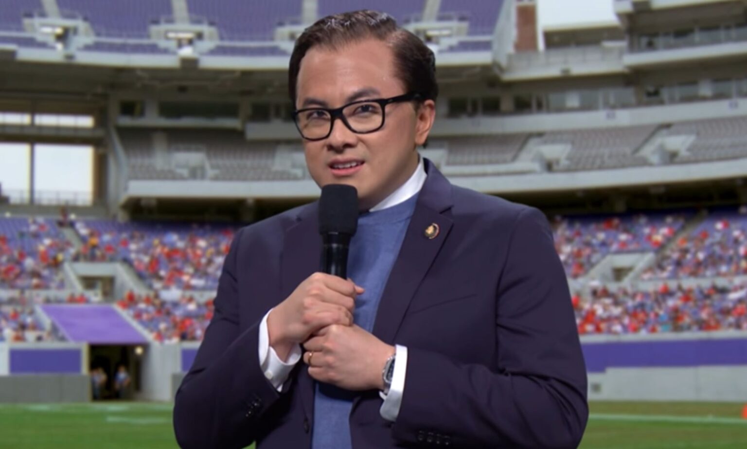 George Santos déchiré après que SNL ait envoyé une drag queen au passé Bowen Yang dressed as George Santos during an SNL skit infront of a greenscreen of an NFL football field.