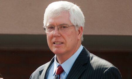 Mat Staver awkwardly smiles during a press conference.