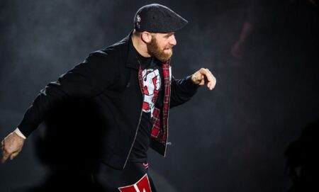 Sami Zayn walks down the ramp of a WWE show during a match.