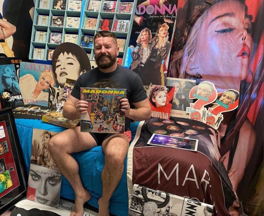 Matt, un super fan de Madonna, assis sur son lit entouré de l'une des plus grandes collections de produits dérivés de Madonna en Australie