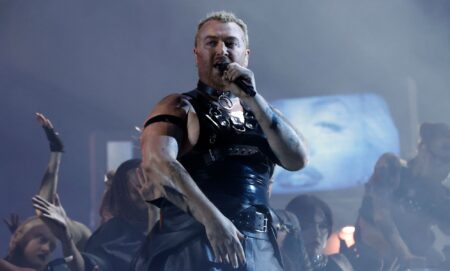 Sam Smith in a latex vest singing on stage at the Brit Awards.