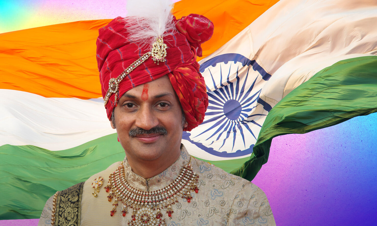 Prince indien gay sur la thérapie de conversion survivante : « Mes parents voulaient opérer mon cerveau » Prince Manvendra Singh Gohil, a smiling man wearing a gold top, red jewelled necklace and red turban with a feather.