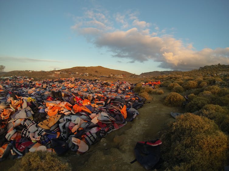 Un paysage vallonné couvert de milliers de gilets de sauvetage.